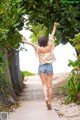 A woman walking down a path with her arms outstretched.