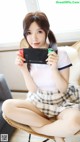 A woman sitting on a chair holding a Nintendo Switch.