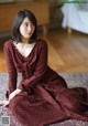 A woman sitting on a rug in a room.