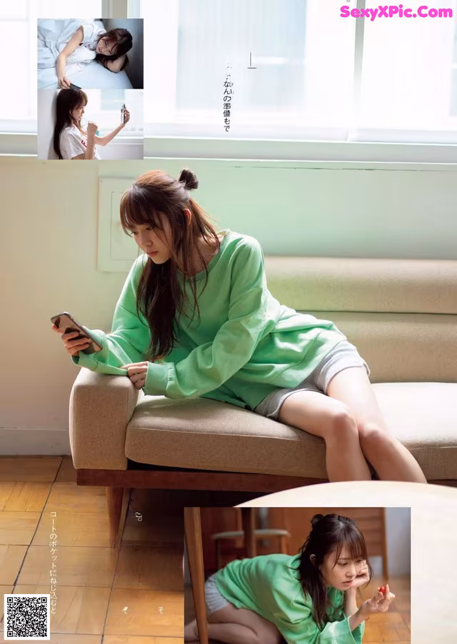 A woman sitting on a couch looking at her phone.