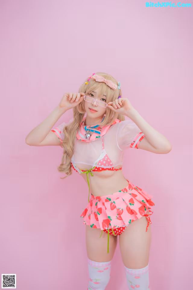 A woman in a pink and white outfit posing for a picture.