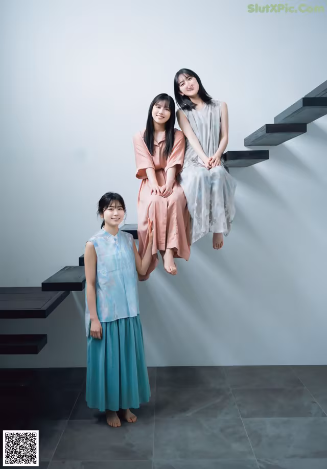 A group of three women sitting on top of a set of stairs.
