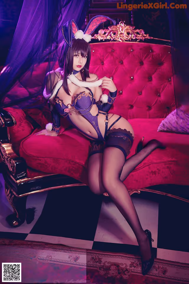 A woman in lingerie sitting on a red couch.