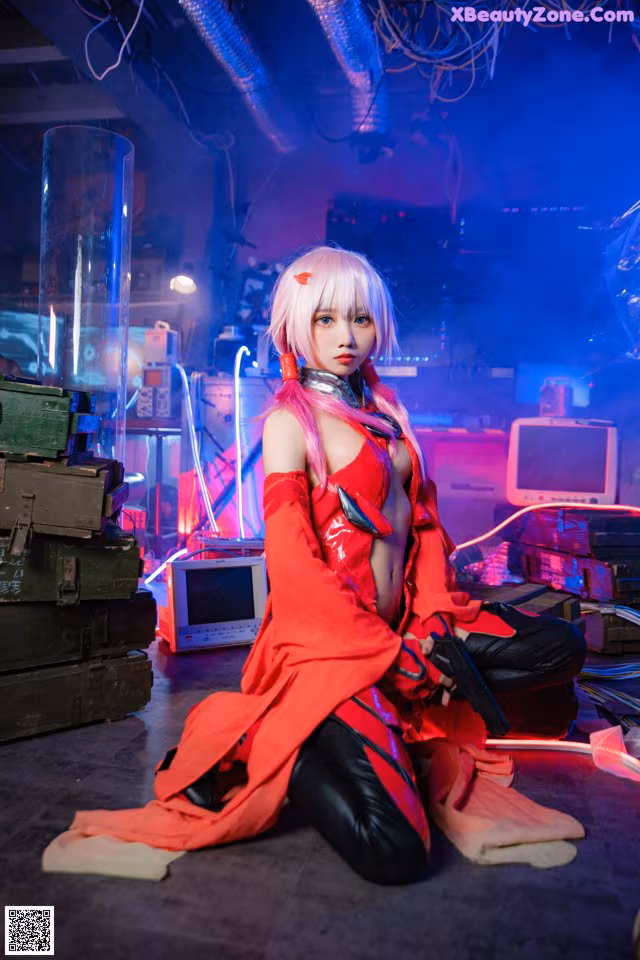 A woman in a red outfit sitting on the ground.