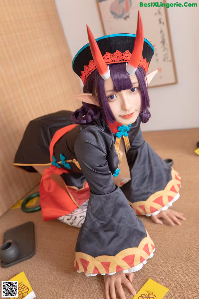 A woman in a black and red outfit with horns on her head.