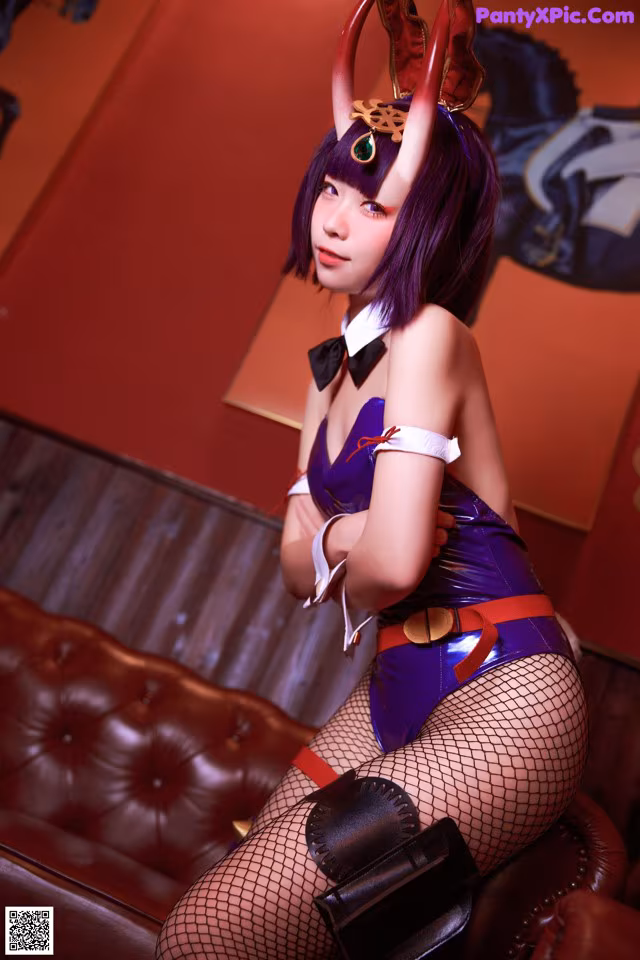 A woman in a costume sitting on a couch.